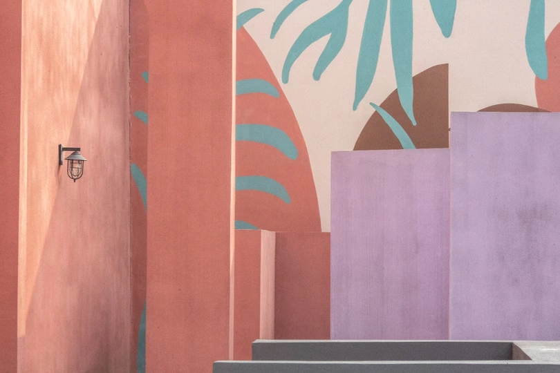 一个带粉红色墙壁和一幅楼梯画间的浴室