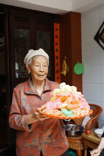 一个老人拿着盘子里的食物 一个年长的女人拿着蛋糕