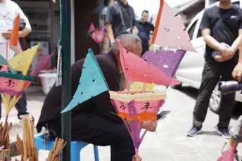 一个坐在椅子上的男人在卖雨伞。