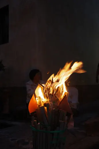 夜晚街道上的一个男孩 手拿一篮蜡烛和燃着的木棍。