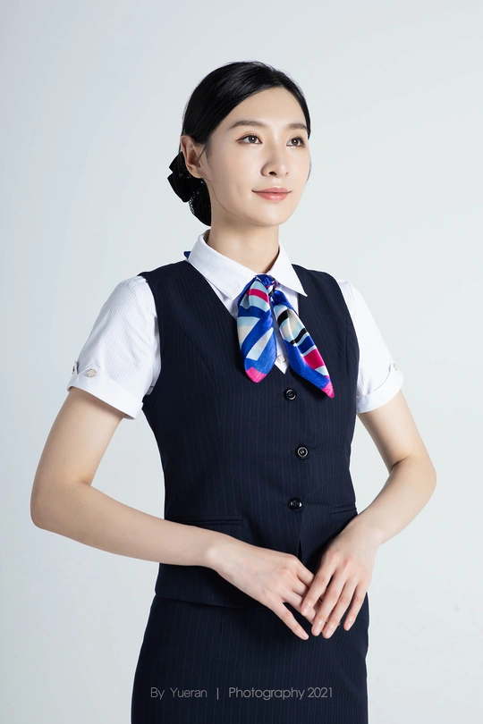 一位穿着黑色连衣裙 配有蓝色围巾的年轻女子