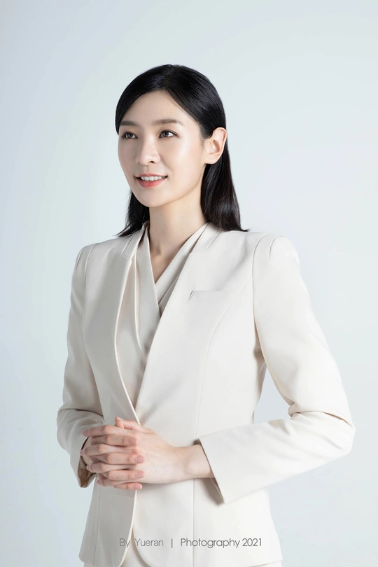 一位穿着白色夹克、身着商务套装的美丽年轻女子