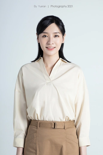 一位穿着白色衬衫、裙子和裤子的年轻女子