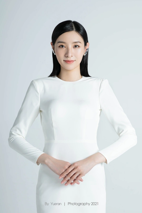 一位穿着长白色连衣裙的美丽年轻女子