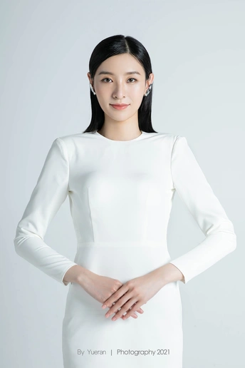 一位穿着长白色连衣裙的美丽年轻女子