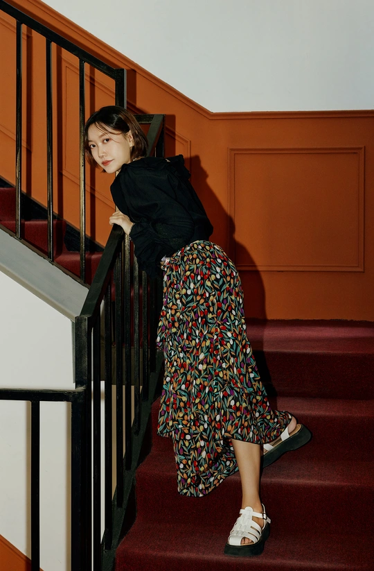 一个穿着黑白裙子的年轻女子坐在一些楼梯上