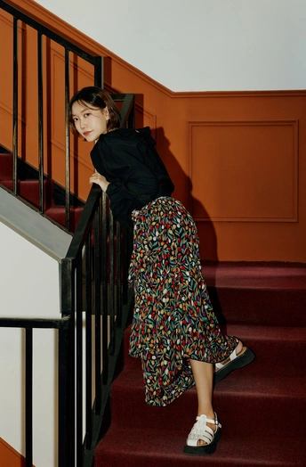 一个穿着黑白裙子的年轻女子坐在一些楼梯上