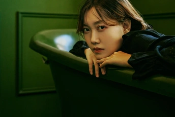 一个小女孩坐在一把绿色椅子上