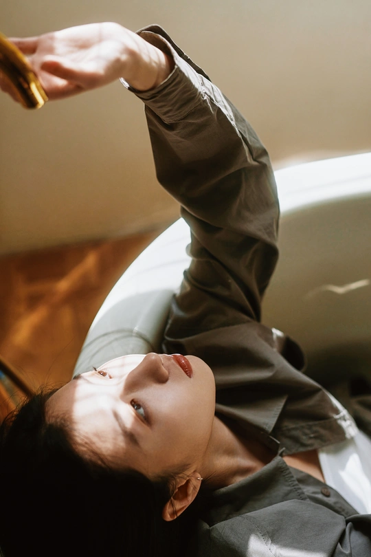 一个年轻女子躺在地上 手按着头发 剪刀放在她的头上。