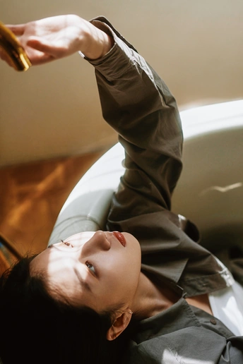 一个年轻女子躺在地上 手按着头发 剪刀放在她的头上。