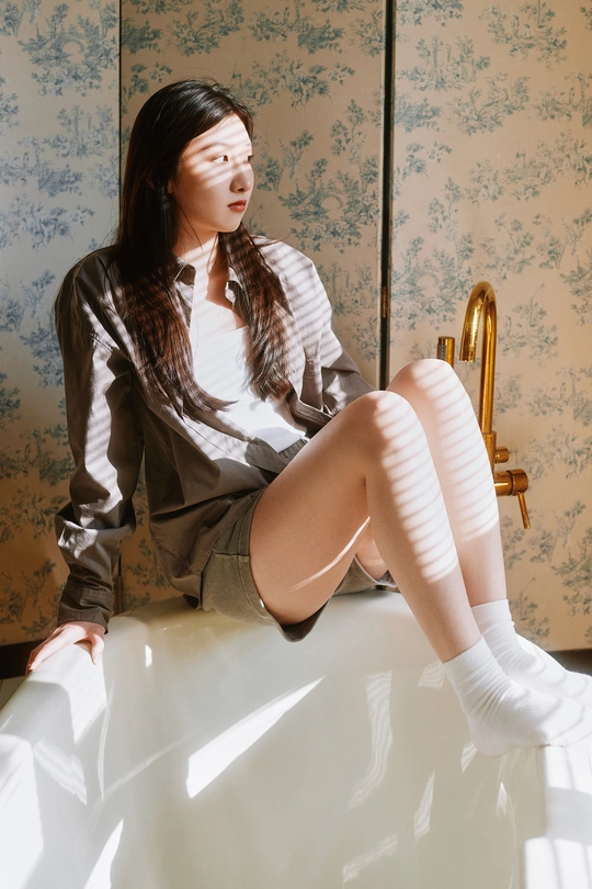 一个穿着白袜子的年轻女子坐在床上