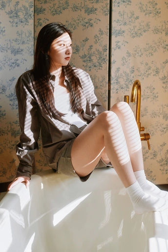 一个穿着白袜子的年轻女子坐在床上