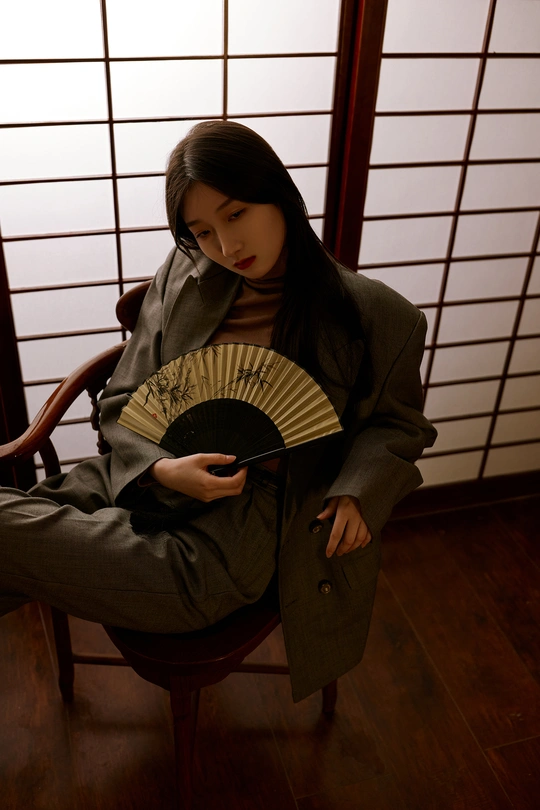 和服少女持扇坐在木椅上