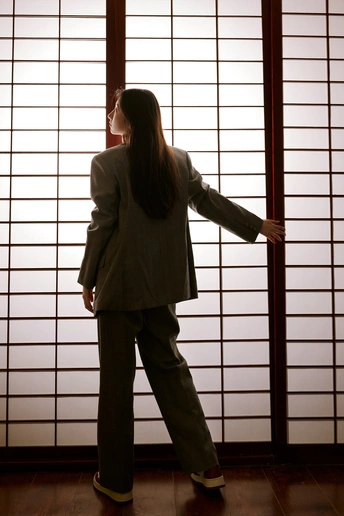 一位穿着西装的女人站在窗户前