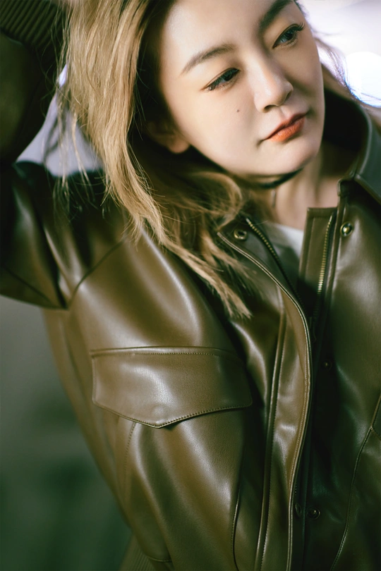 美丽的年轻女子 棕色头发 身穿皮夹克 为肖像摆姿势