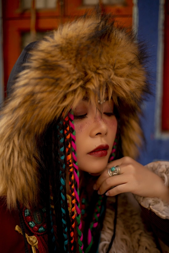 一位戴帽子、外套、皮草、口红和戒指的女青年