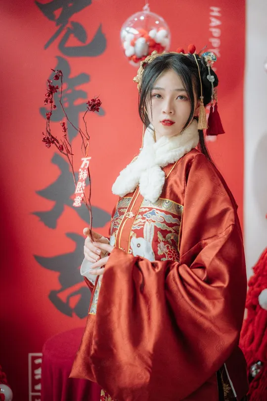 一位穿着传统服装的女士 身着红色和服 手持花束