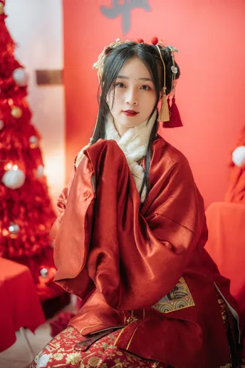 一位穿着传统服装的女孩在圣诞树下摆姿势