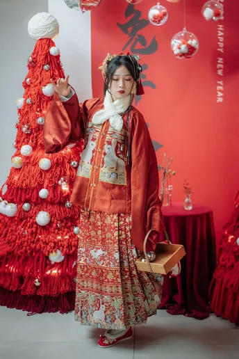 一位穿着传统服装的女性站在圣诞树前