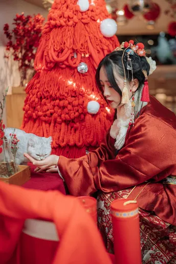 一位穿着红色的年轻女子坐在桌子旁