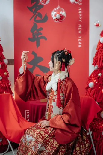 一位穿着传统服装的女性在圣诞树下摆姿势