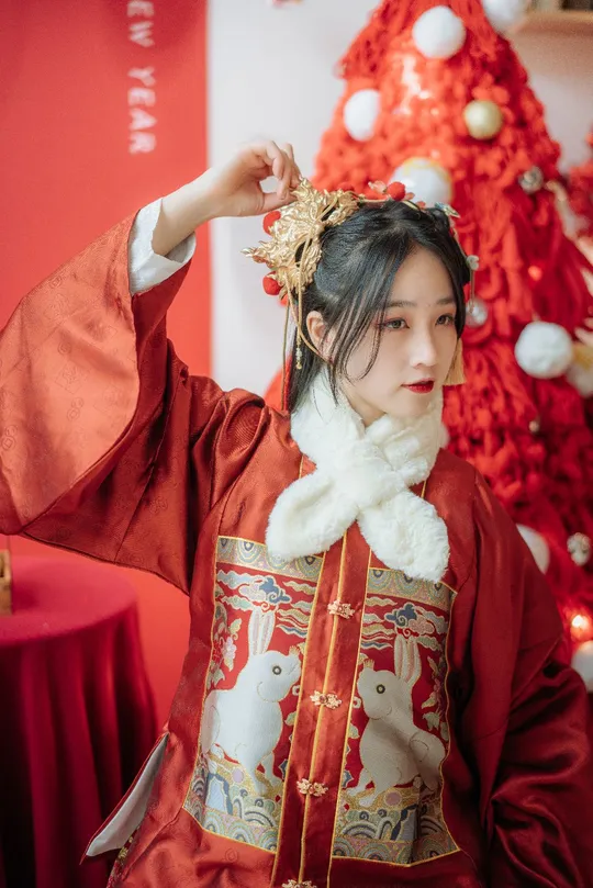 一位穿着传统服装的年轻女子在圣诞树前摆姿势