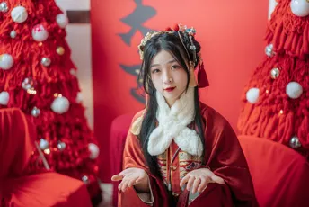 一位穿着costume的年轻女子坐在装饰有圣诞树的红色椅子上