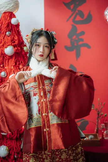 一位穿着传统服装的女性在圣诞树下摆姿势