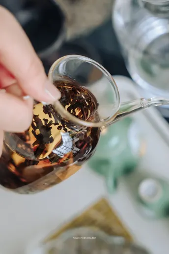 一个人用勺子往杯子里倒茶