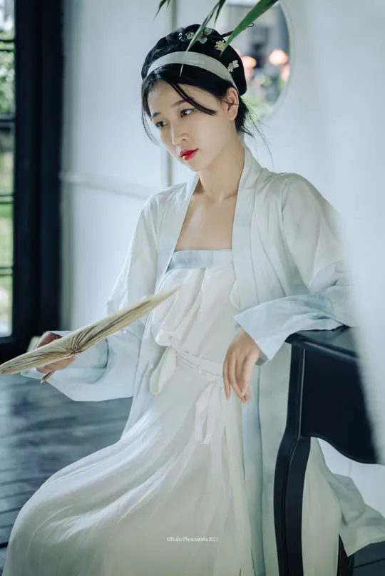 一位穿着白色连衣裙的女巫拿着魔杖