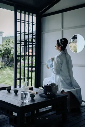 一位穿着白色衣服的女人坐在桌子旁