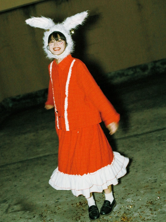 一个穿着橙红色服装的年轻女孩