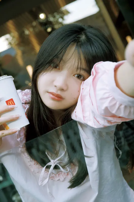 一位年轻女子拿着一杯可乐