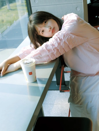 一个年轻人坐在桌子前 看着窗外 小女孩靠在柜台上