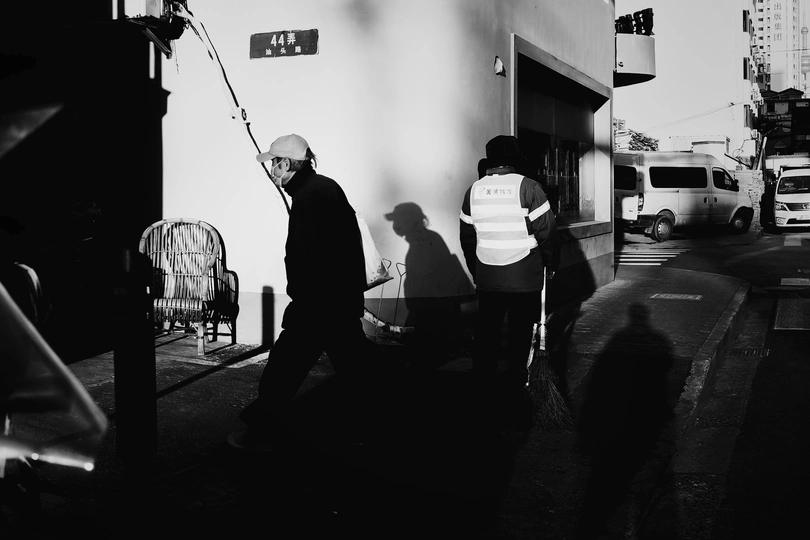 一个人在街上走在其他人旁边