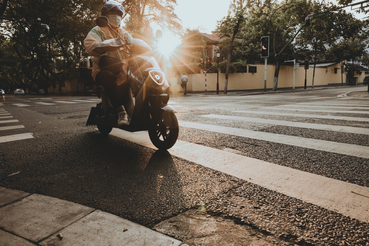 一个人骑着摩托车在十字路口沿街行驶