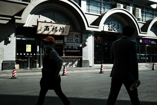 一些人在街上走 前面有一栋楼。