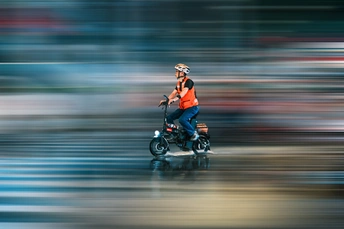 一张模糊的照片 一个男人骑摩托车在街上