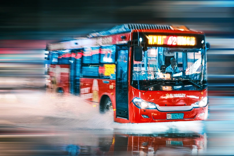 雨中行驶的模糊的红色公交车