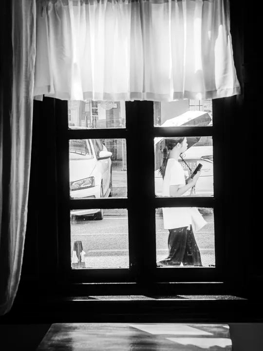 一位女士正在窗口看着另一个人