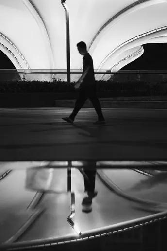 一张黑白照片 一个男子在晚上骑滑板