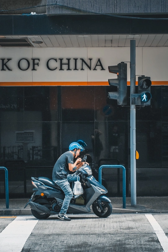 一个人骑着摩托车在交通信号灯旁边的一条街上