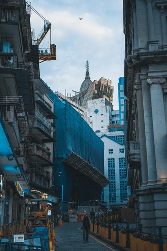 城市中的一条小巷 有蓝色建筑和远处的起重机。