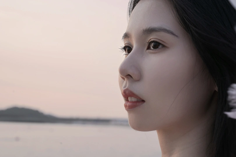 一位身穿白色连衣裙、头发上插着鲜花的年轻女子的肖像