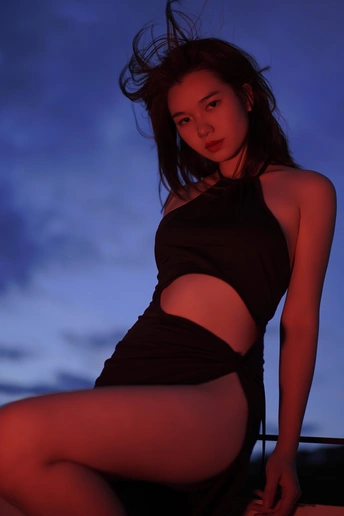 背景是蓝天的阳台上的一名黑衣女子