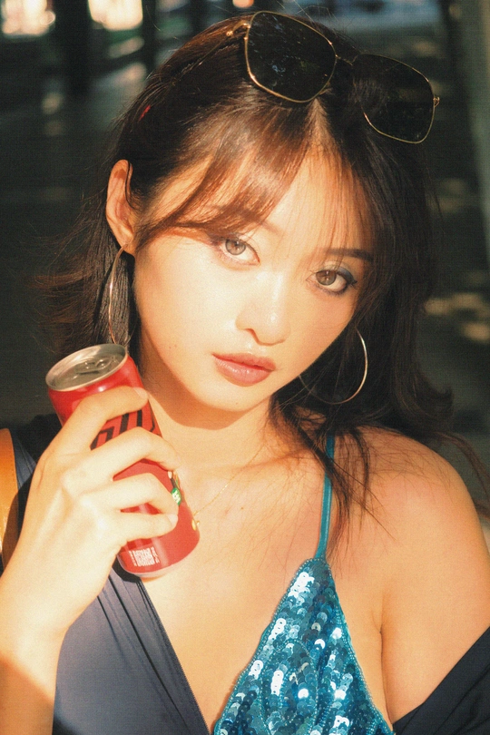 一个戴着墨镜的年轻女子拿着一罐红色饮料