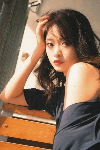 一个穿着黑色连衣裙的年轻女子把头靠在木长椅上