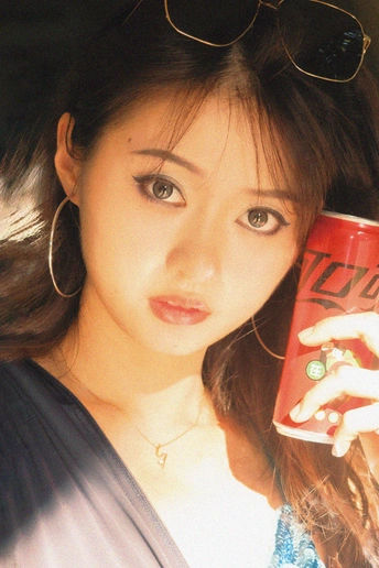 一个戴着墨镜的年轻女子拿着一个红色的咖啡杯 里面有饮料