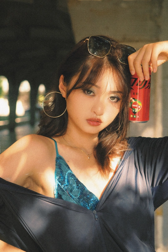 一个戴着墨镜拿着一罐汽水的年轻女子