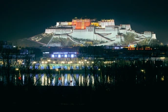 夜晚照亮的一座大城堡 位于湖边。